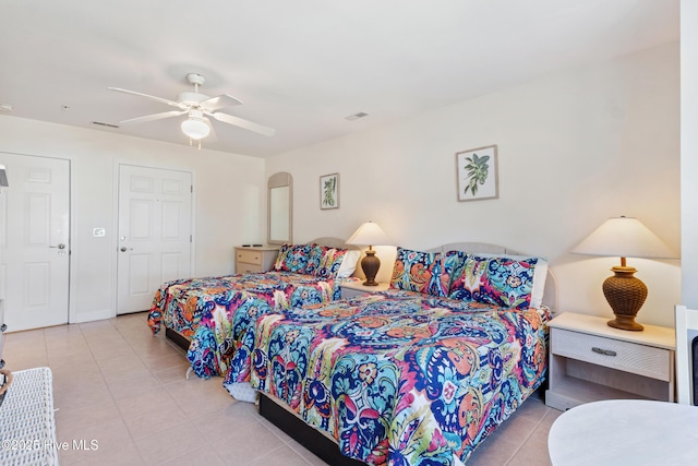 bedroom featuring arched walkways, ceiling fan, light tile patterned floors, visible vents, and baseboards