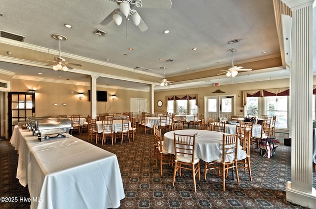 dining space featuring a raised ceiling, visible vents, and a healthy amount of sunlight