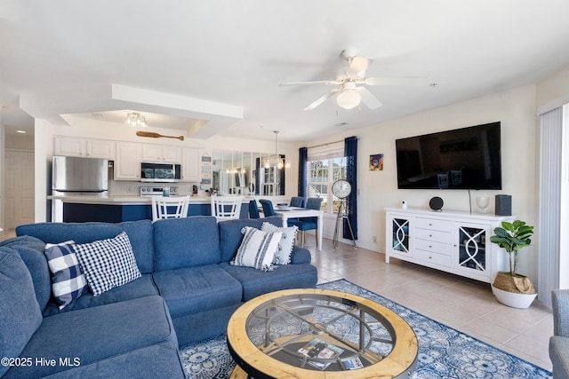 living area with light tile patterned floors and a ceiling fan