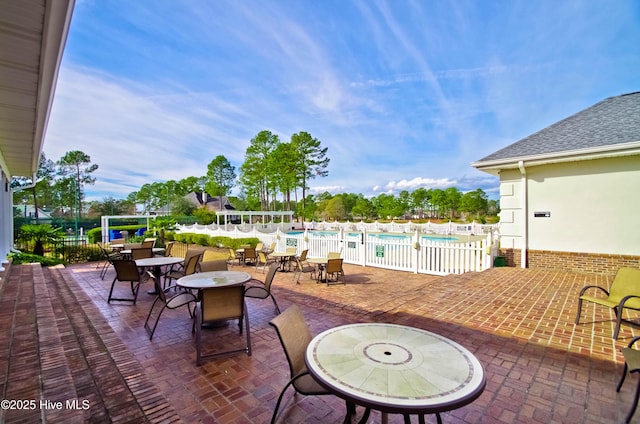 view of patio / terrace featuring fence and a community pool