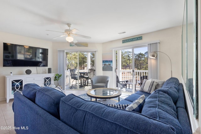 living room featuring light tile patterned floors, plenty of natural light, visible vents, and a ceiling fan