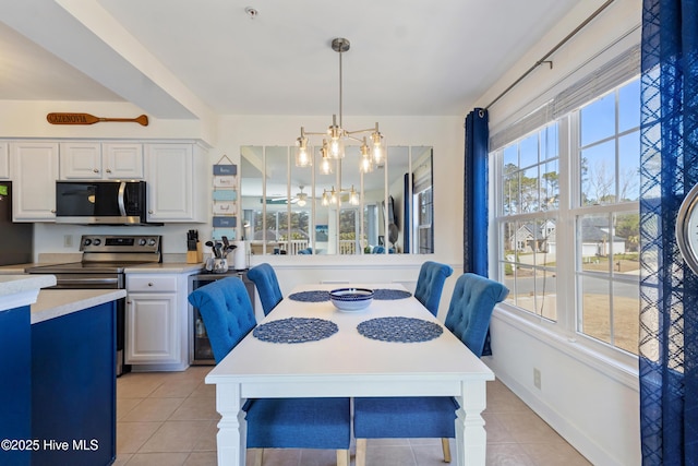 dining area featuring light tile patterned floors, baseboards, and an inviting chandelier