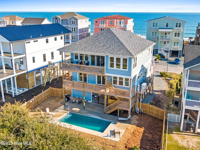 rear view of house featuring a patio, a water view, and a fenced backyard