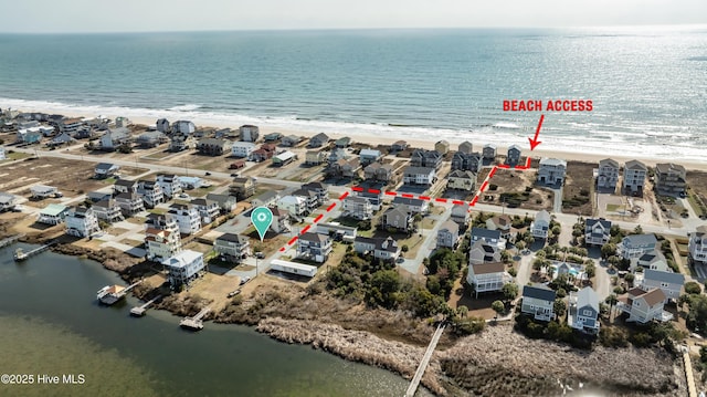 birds eye view of property featuring a view of the beach, a water view, and a residential view