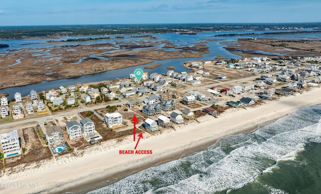 drone / aerial view featuring a residential view, a water view, and a beach view