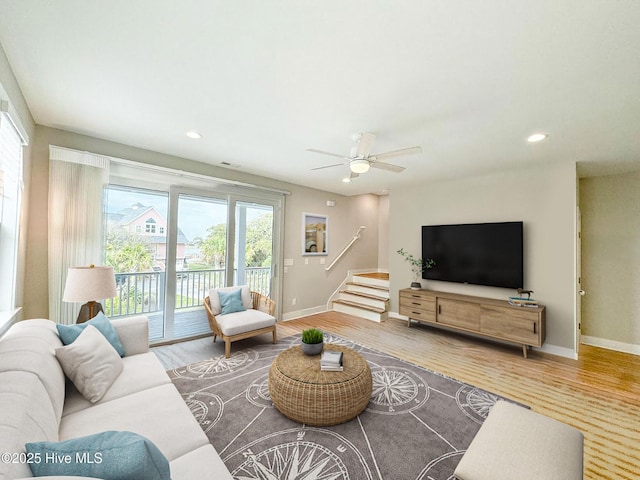 living area featuring recessed lighting, wood finished floors, baseboards, and stairs