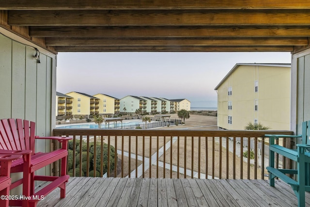 deck at dusk featuring a community pool