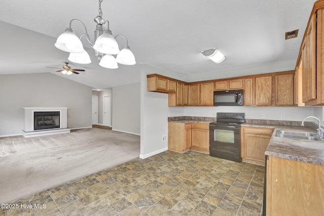 kitchen with a fireplace with raised hearth, brown cabinets, black appliances, pendant lighting, and a sink