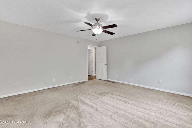 unfurnished room with carpet flooring, a ceiling fan, and baseboards