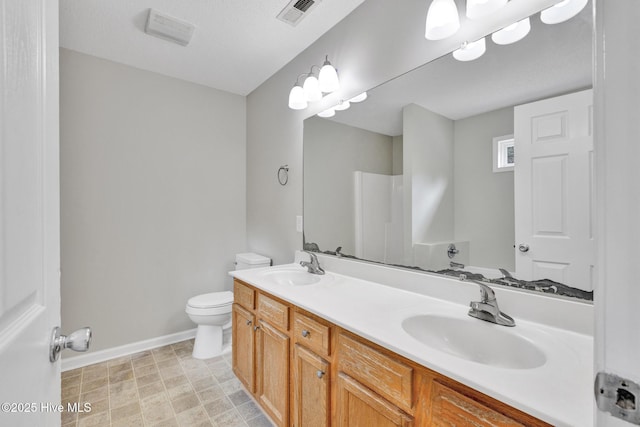 full bath with visible vents, a sink, toilet, and double vanity