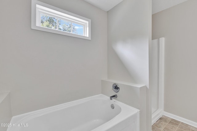 full bath featuring a garden tub, baseboards, and walk in shower