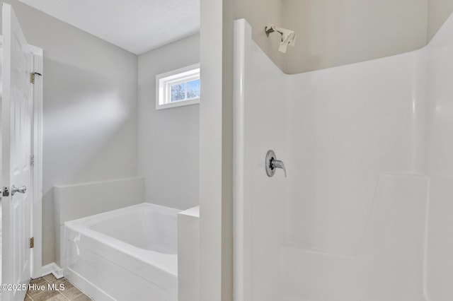 bathroom featuring walk in shower and a bath