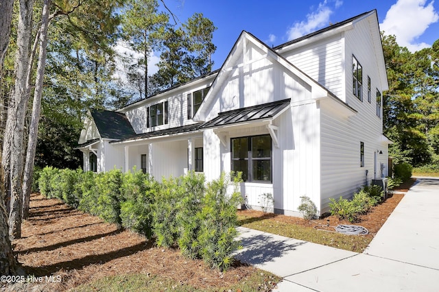 view of front of home with board and batten siding, a standing seam roof, covered porch, and metal roof