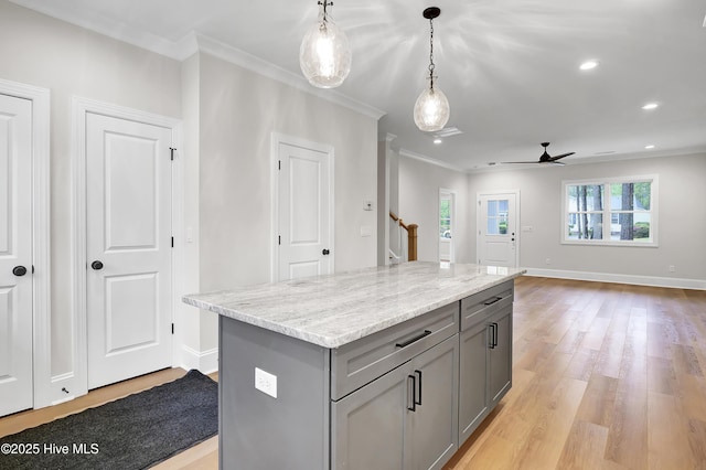 kitchen featuring a center island, gray cabinets, hanging light fixtures, light wood-style floors, and open floor plan