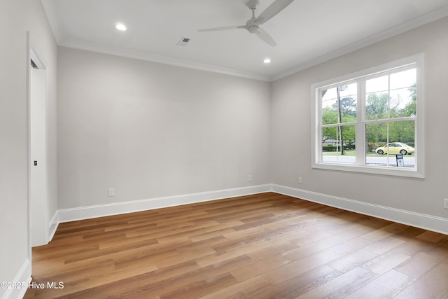 spare room featuring ornamental molding, visible vents, light wood-style flooring, and baseboards