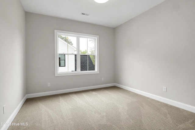 spare room with baseboards, visible vents, and carpet flooring