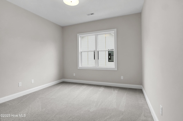 carpeted empty room featuring visible vents and baseboards