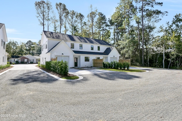 modern inspired farmhouse with driveway and fence