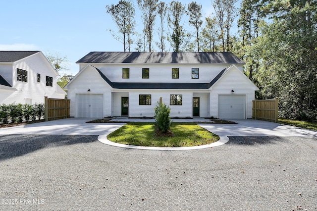 modern inspired farmhouse featuring concrete driveway, an attached garage, and fence