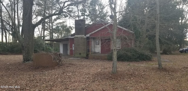 view of front of property featuring brick siding and a chimney