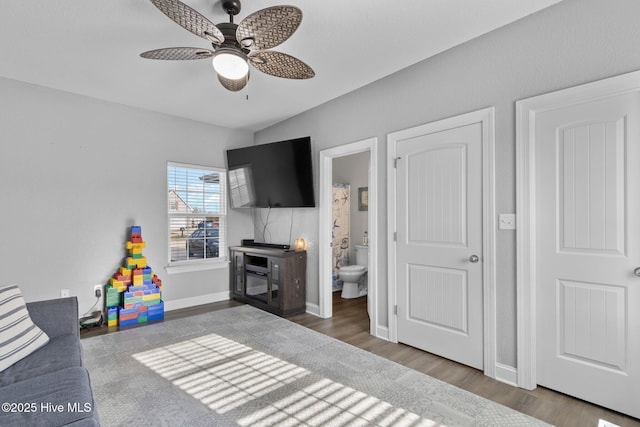 recreation room featuring baseboards, dark wood-style flooring, and a ceiling fan