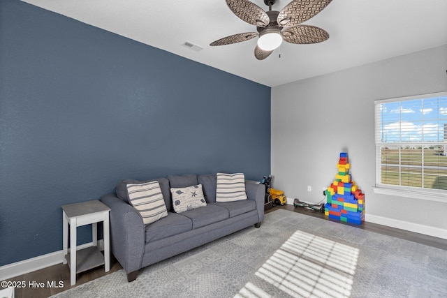 living area featuring ceiling fan, wood finished floors, visible vents, and baseboards