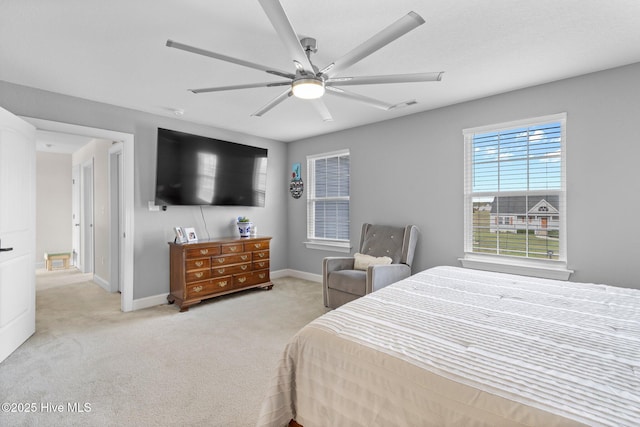 bedroom with a ceiling fan, light carpet, and baseboards