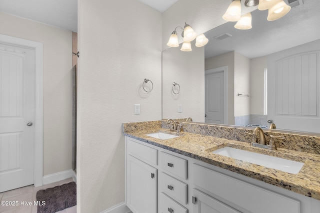 bathroom featuring visible vents, a sink, baseboards, and double vanity