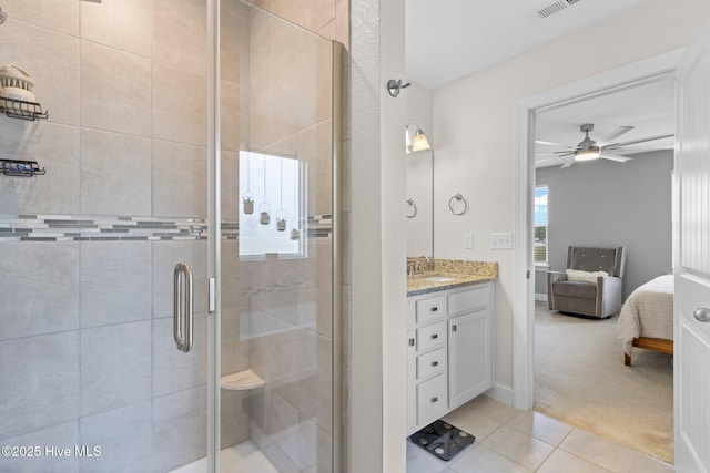 bathroom with ceiling fan, vanity, a shower stall, tile patterned floors, and ensuite bath