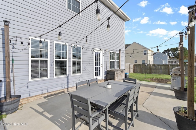 view of patio featuring grilling area, fence, and outdoor dining area