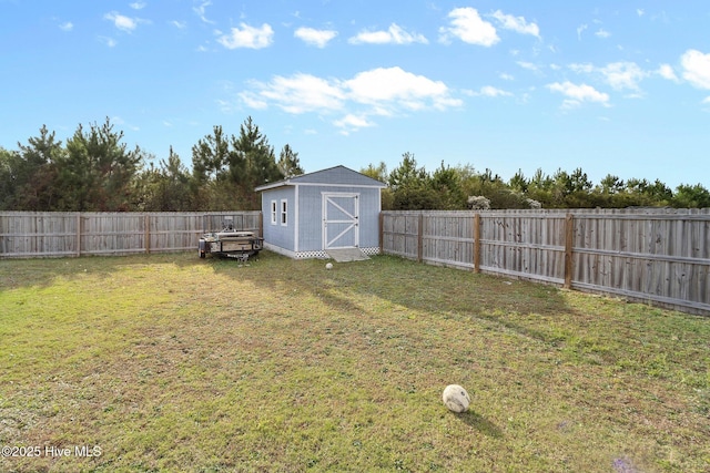 view of yard with an outbuilding, a shed, and a fenced backyard