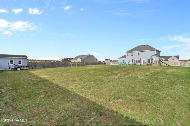 view of yard featuring a fenced backyard, a residential view, and a playground