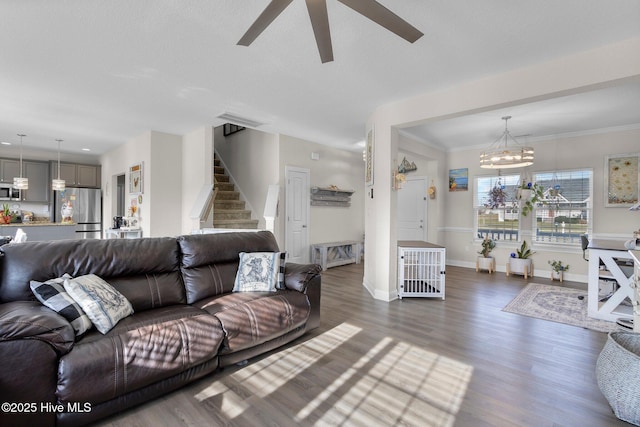 living area featuring stairway, dark wood finished floors, visible vents, and crown molding