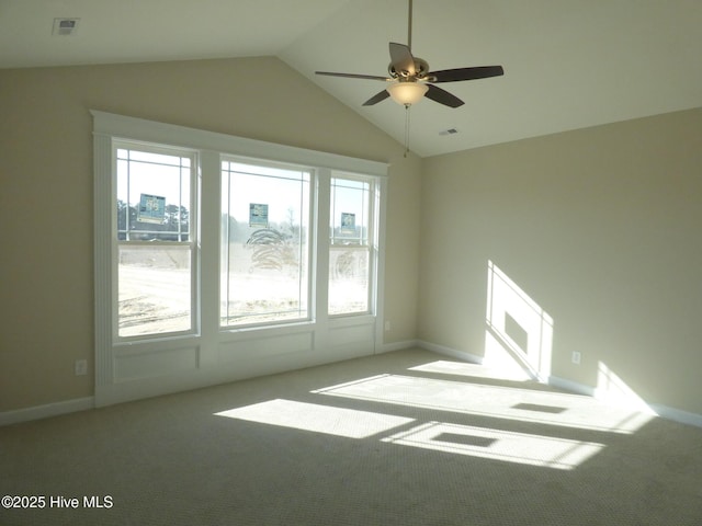 spare room featuring a ceiling fan, lofted ceiling, visible vents, and light carpet