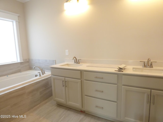 full bath with double vanity, a sink, and a bath