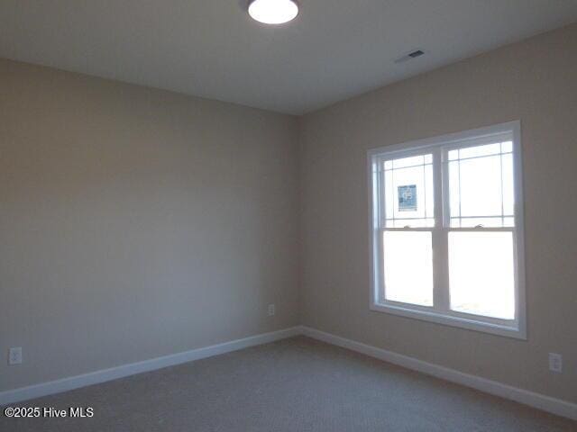 unfurnished room featuring carpet and baseboards