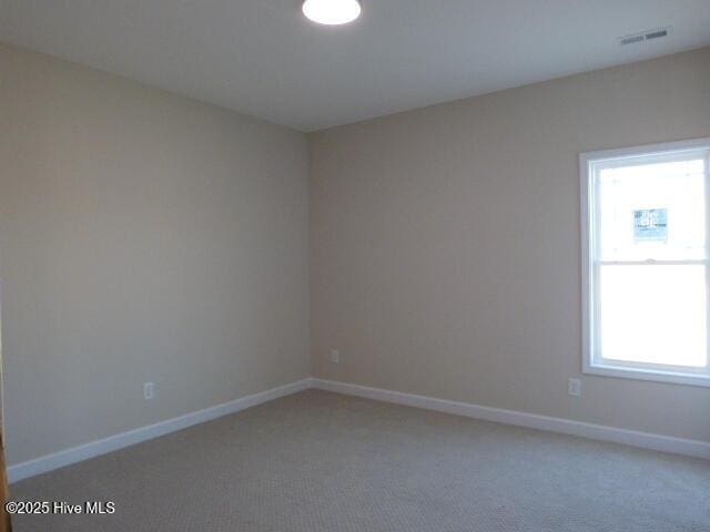 carpeted spare room with baseboards and visible vents