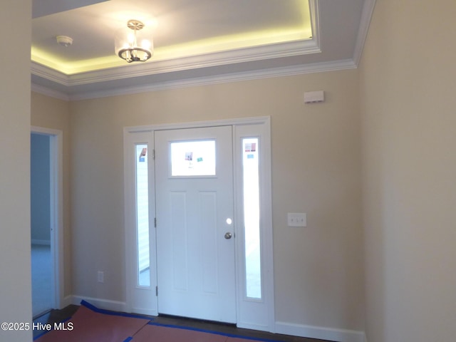 foyer with plenty of natural light, baseboards, and crown molding