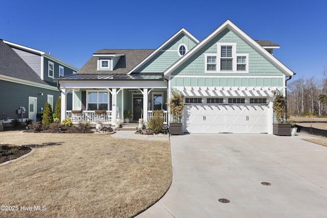 craftsman inspired home featuring a garage, concrete driveway, covered porch, a standing seam roof, and board and batten siding