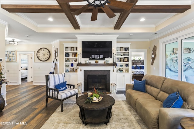 living room with beam ceiling, a wealth of natural light, a glass covered fireplace, wood finished floors, and coffered ceiling