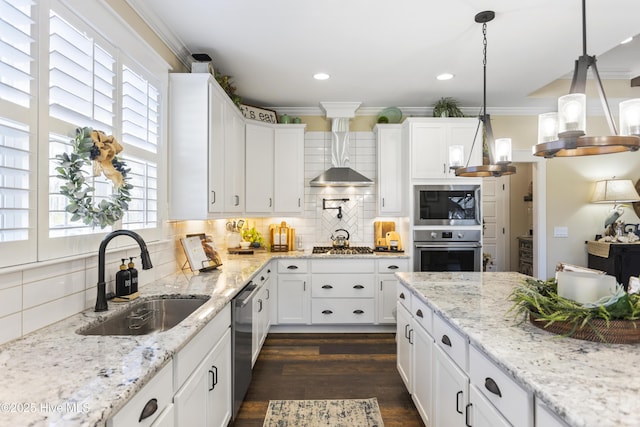 kitchen featuring wall chimney exhaust hood, appliances with stainless steel finishes, ornamental molding, a sink, and backsplash