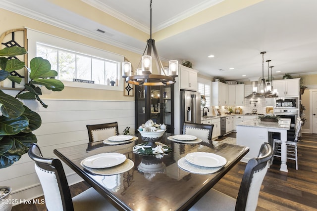 dining room featuring an inviting chandelier, visible vents, dark wood-style flooring, and ornamental molding