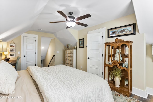 bedroom with vaulted ceiling, ceiling fan, wood finished floors, and baseboards