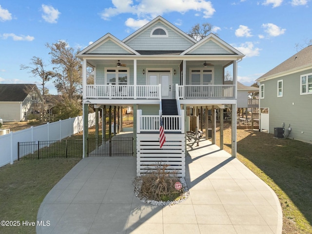 raised beach house with ceiling fan, a carport, a porch, and driveway