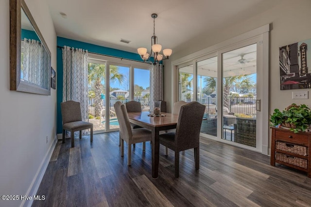 dining space with baseboards, dark wood-type flooring, visible vents, and an inviting chandelier