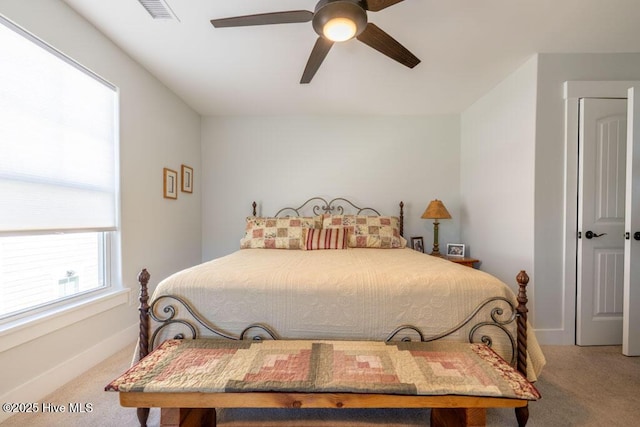 carpeted bedroom with baseboards, visible vents, and a ceiling fan