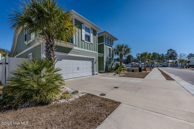 view of side of property featuring driveway, board and batten siding, and an attached garage