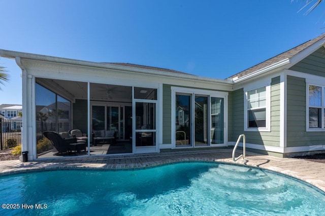 view of pool with a sunroom, ceiling fan, a patio area, and a fenced in pool