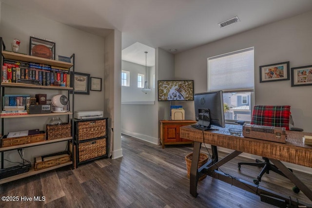 office area featuring dark wood-type flooring, visible vents, and baseboards