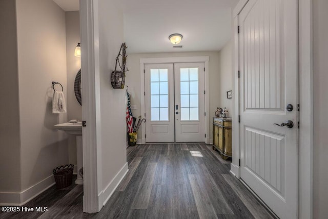 doorway to outside with dark wood-style flooring and baseboards